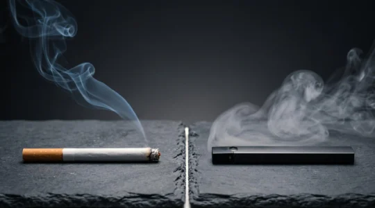 Une cigarette classique et une cigarette electronique posees cote a cote sur une surface sombre, symbolisant le choix entre tabac et vapotage