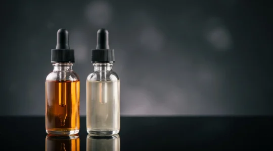 Deux flacons de concentre aromatique compares cote a cote sous une lumiere contrastee, l'un dore et lumineux, l'autre terne, symbolisant la difference entre un arome premium et un arome bas de gamme