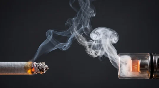 Braise d'une cigarette et bobine incandescente d'une cigarette électronique face à face, symbolisant la comparaison du coup en gorge