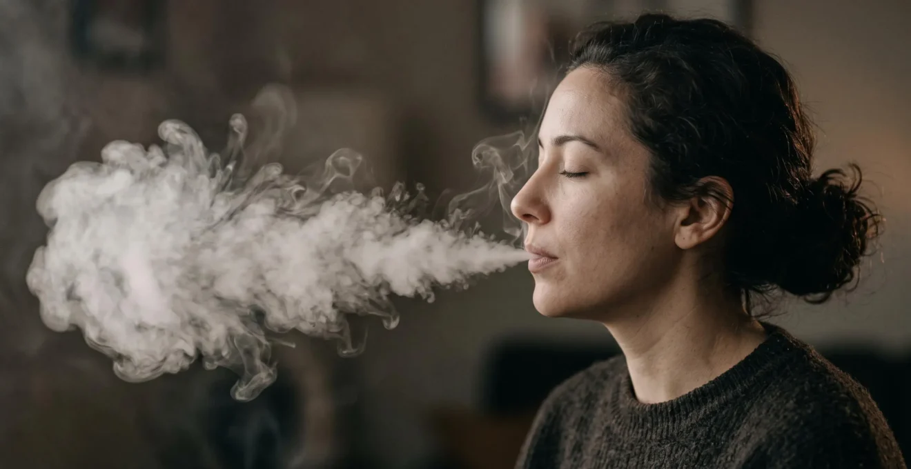 Vapoteur exhalant un nuage de vapeur epais et dense dans une lumiere douce, illustrant l'effet de la glycerine vegetale